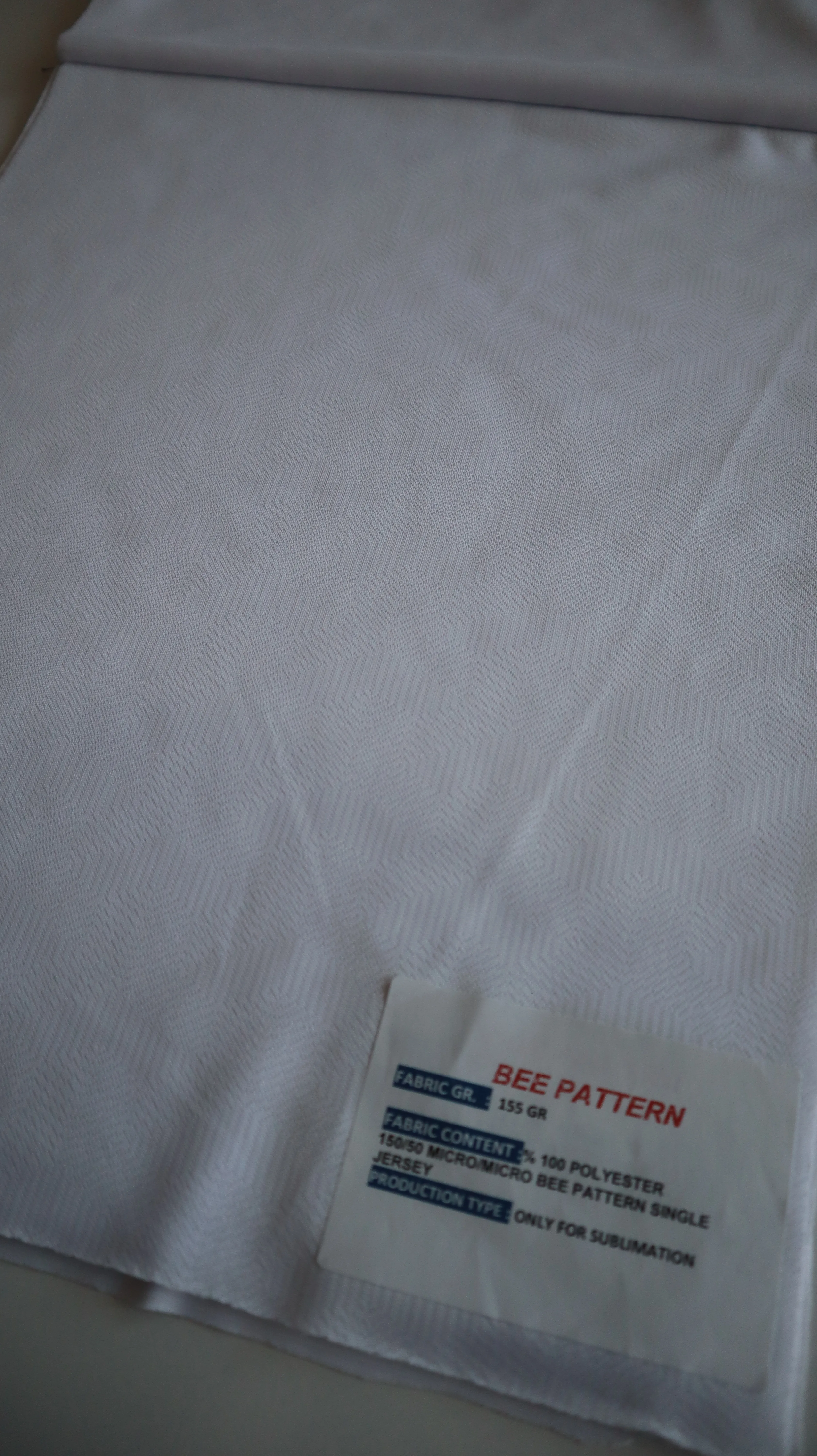 Performance sportswear fabric construction close-up showing knit surface and stretch