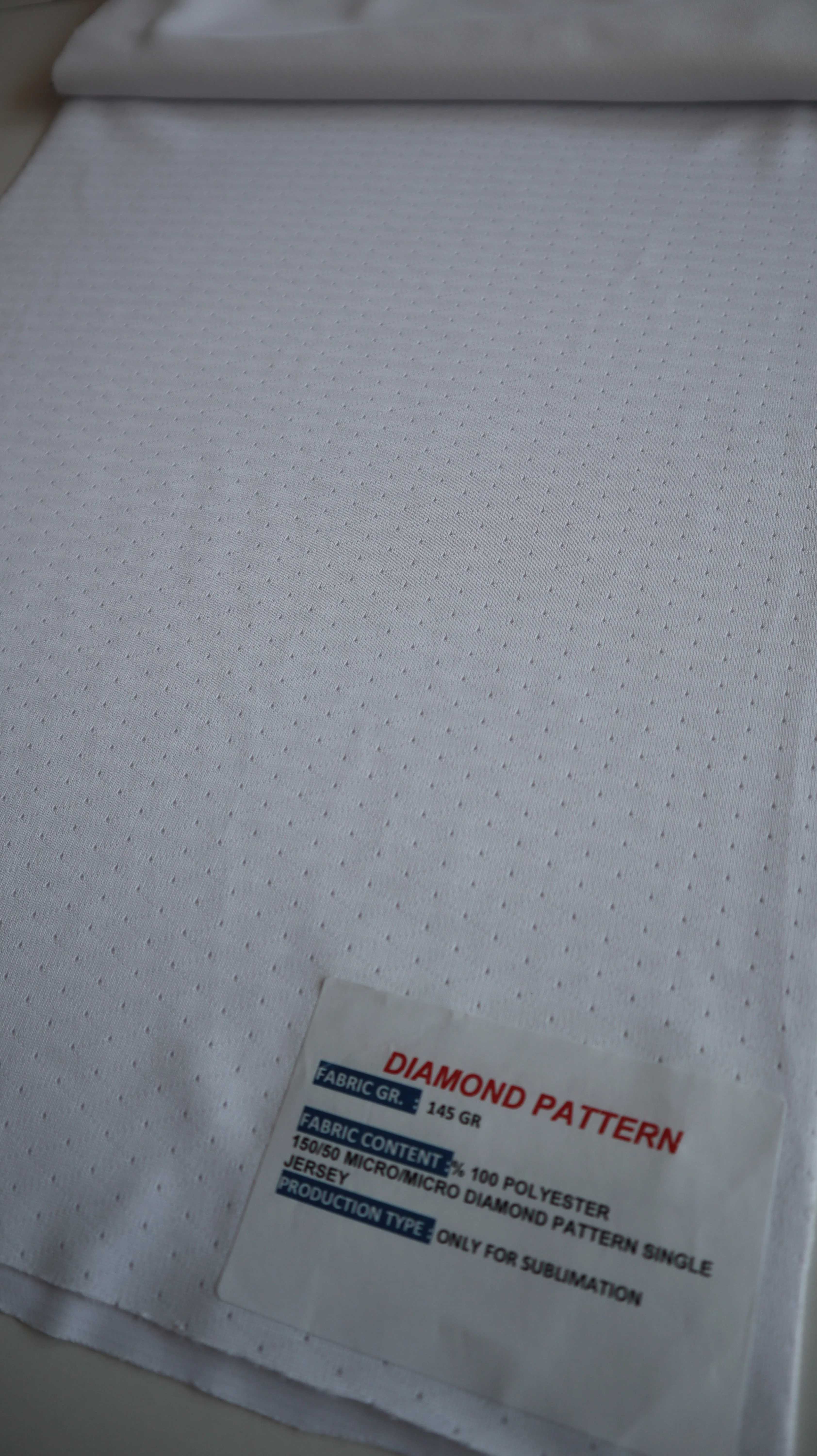 Performance sportswear fabric construction close-up showing knit surface and stretch